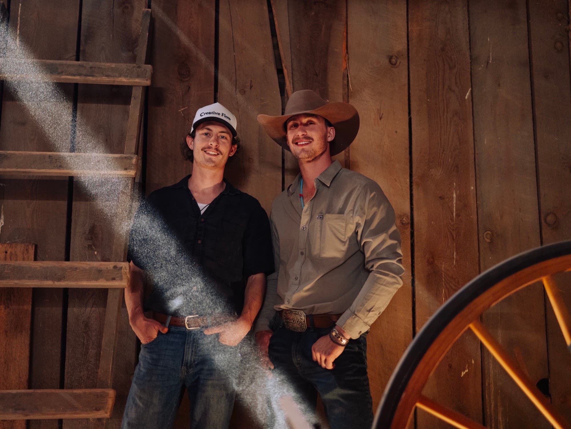 Kahlil and Wes in a barn, a beam of dusty light between them